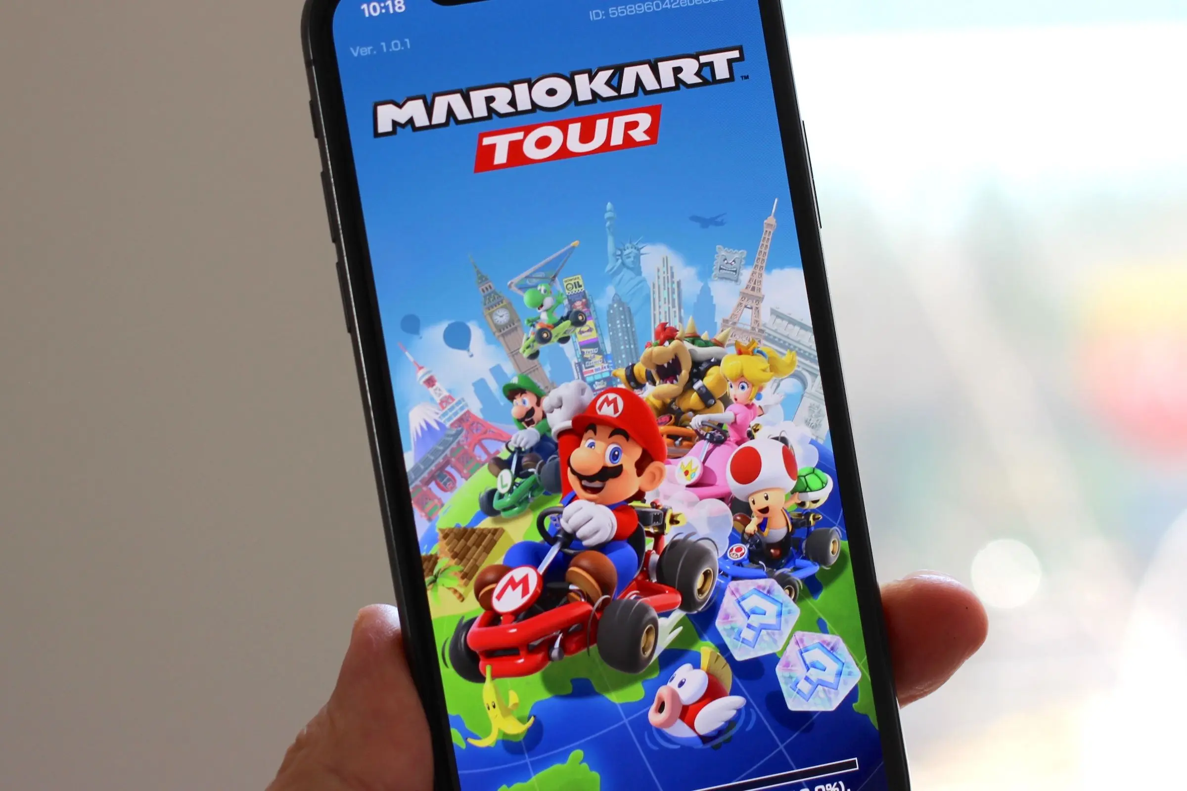 Mario Kart Tour game screen with characters and iconic landmarks.